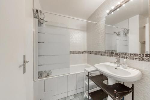 une salle de bain blanche avec un lavabo et une douche dans l'établissement 4 min walk to Metro, 60m², renovated, La Défense, à Puteaux