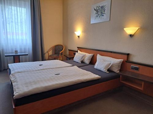 a hotel room with a bed with white sheets and pillows at Landhotel Zur alten Post in Lohr