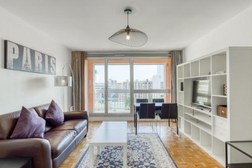 un salon avec un canapé et une table dans l'établissement 4 min walk to Metro, 60m², renovated, La Défense, à Puteaux