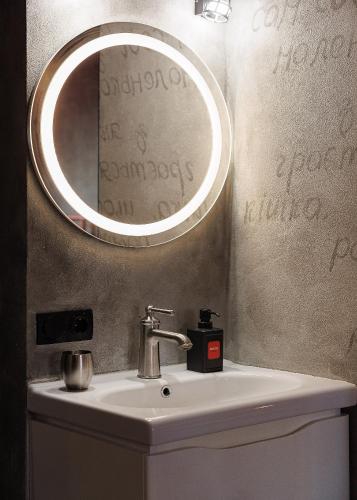 a bathroom with a sink and a mirror at Masoch. Hotel & Cafe in Lviv