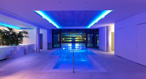 a swimming pool in a building with blue lights at Ca' Apollonio Heritage in Romano D'Ezzelino