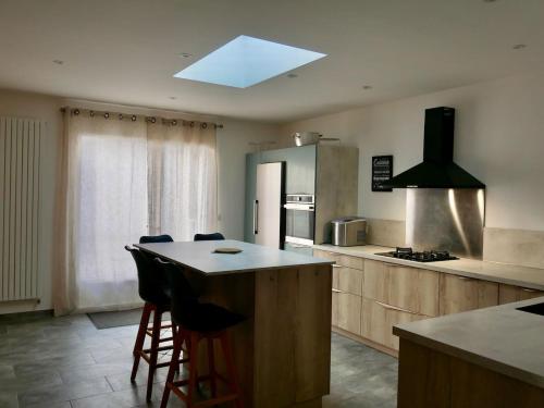 une cuisine avec un îlot au milieu d'une cuisine dans l'établissement Grande Maison au bord du lac Salonique, au Grau-du-Roi