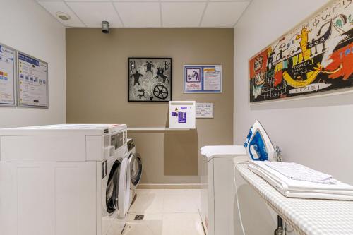 a laundry room with a washer and dryer at Adagio Nice Centre in Nice