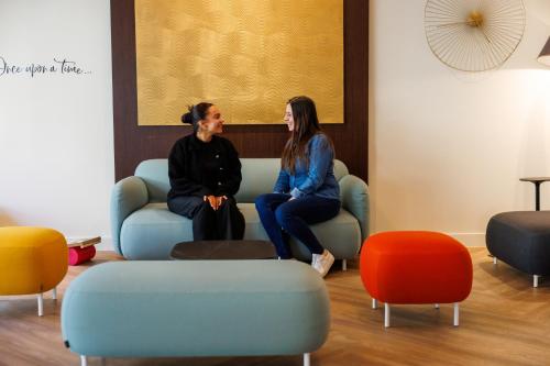 two women sitting on a couch in a waiting room at Adagio Nice Centre in Nice