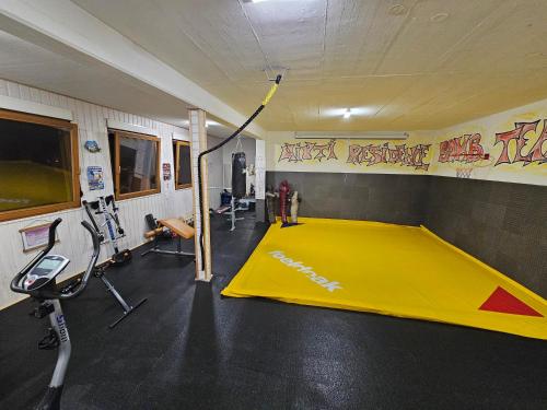 a gym with a yellow trampoline in a room with graffiti at Miuti Residence in Triberg