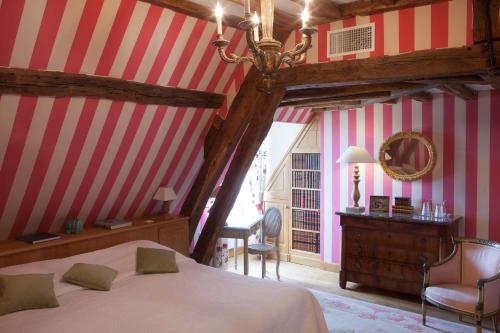 a bedroom with red and white striped walls and a bed at Château-Hôtel de Bourron in Bourron-Marlotte