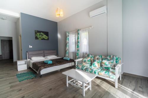 a bedroom with a bed and a couch and a chair at La Casa Sorento in Victoria