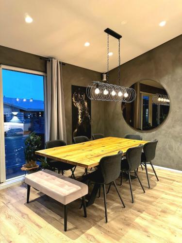 a dining room with a wooden table and chairs at Luxury row house in quiet area with infrared sauna and hot tub in Mosfellsbær