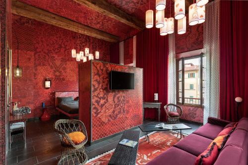a living room with a purple couch and red walls at 25hours Hotel Florence Piazza San Paolino in Florence
