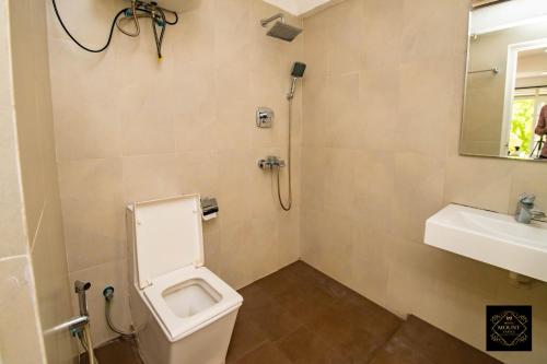 a bathroom with a toilet and a sink and a mirror at Hotel Mount Castle in Hatton