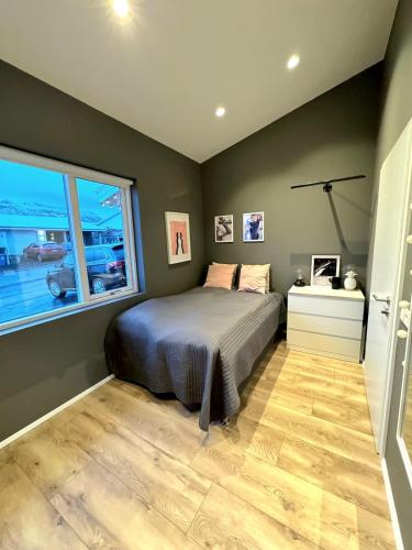 a bedroom with a bed and a window at Luxury row house in quiet area with infrared sauna and hot tub in Mosfellsbær