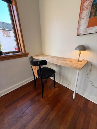 a desk with a chair and a lamp in a room at Folsted - Værelse 101 med eget badeværelse og fri parkering in Bindslev