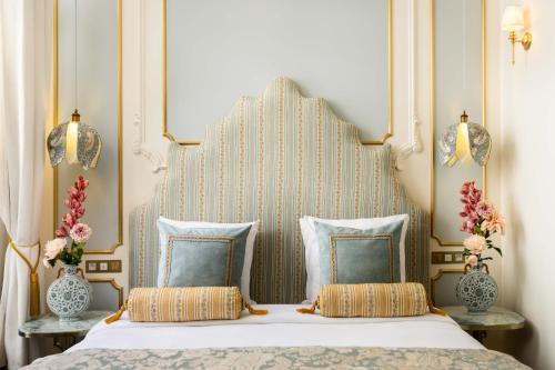 une chambre avec un grand lit avec une grande tête de lit dans l'établissement The Angelina Suite - Champs Elysées, à Paris