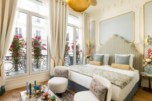 une chambre avec un grand lit et deux fenêtres dans l'établissement The Angelina Suite - Champs Elysées, à Paris