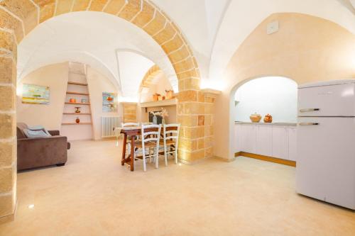 a kitchen and living room with arches and a table at Villa Luritu Luxury Pool Tricase by HDSalento in Tricase