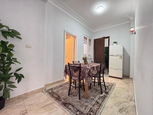 a dining room with a table and chairs and a refrigerator at Casa Del Sol Downtown Cairo in Cairo