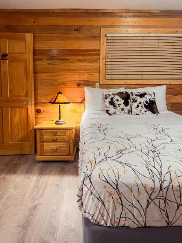 a bedroom with a bed and a lamp on a night stand at Cozy cabin Steps from Lake and Board walk, 5 min RMNP, Moose Lodge Studio in Grand Lake