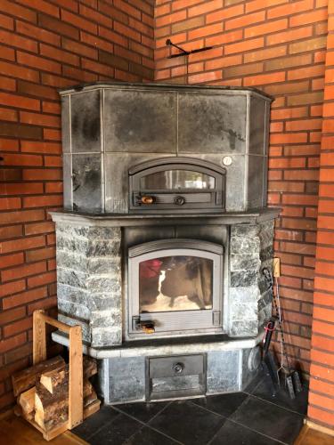 a stone fireplace with a tv on top of it at Lomatalo Aurinkorinne Punkaharjulla in Punkaharju