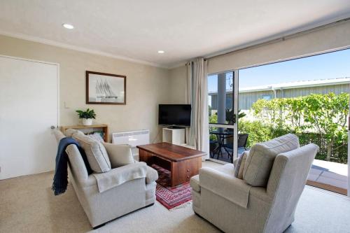 a living room with two chairs and a television at Wonderful Guest Suite Steps to St Heliers Beach in Auckland