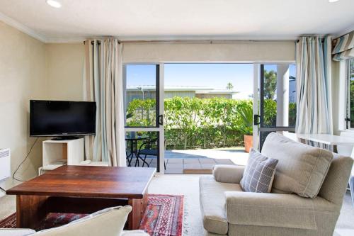 a living room with a couch and a tv at Wonderful Guest Suite Steps to St Heliers Beach in Auckland