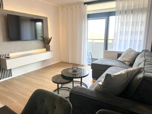 een woonkamer met een bank en een tv bij Forst & Flair Apartment in Bad Harzburg