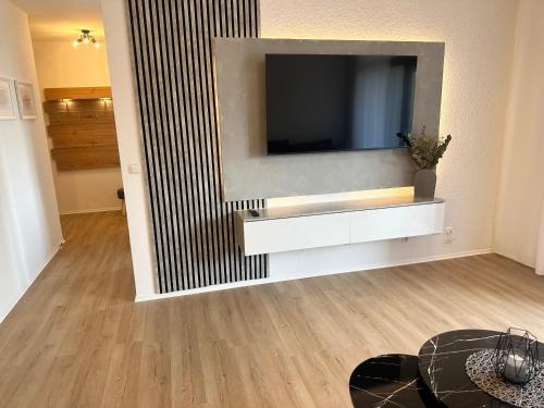 een woonkamer met een televisie aan de muur bij Forst & Flair Apartment in Bad Harzburg