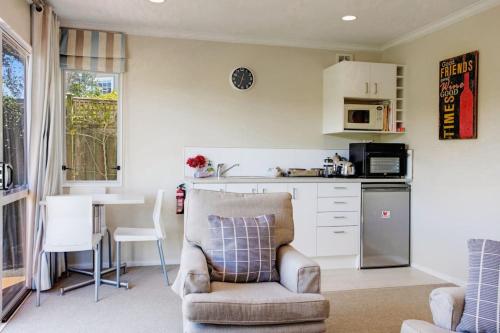 a kitchen with a chair and a table in a kitchen at Wonderful Guest Suite Steps to St Heliers Beach in Auckland
