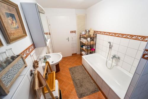 a bathroom with a tub and a sink at Bed and Breakfast Petra Huber in Vichtenstein