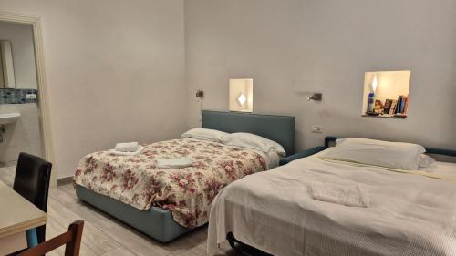 sypialnia z 2 łóżkami, stołem i lustrem w obiekcie Casa Isabella De Luxe Studio w mieście Monterosso al Mare