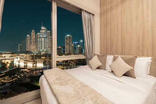 a bed in a room with a view of a city at NEW YEARS Luxury Burj Khalifa and Fountain Views in Dubai