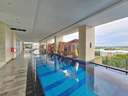 a large swimming pool in a building with a view at Apartemen B Residence By LiviRooms BSD CITY in Cilandak