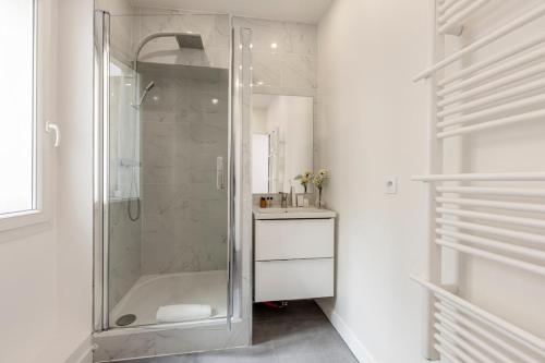 une salle de bain blanche avec une douche et un lavabo dans l'établissement 32#Opera#GrandsBoulevards#Louvre#AC, à Paris