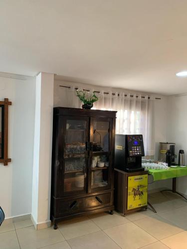 a room with a cabinet with a television and a table at CR Hotel Bueno in Goiânia