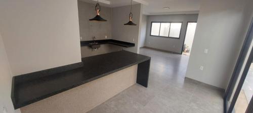 a kitchen with a black counter top in a room at Casa Europa Barretos in Barretos
