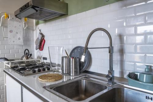 a kitchen counter with a sink and a stove at Relax a due passi dal mare dall'aeroporto"casettaStella" in Focene