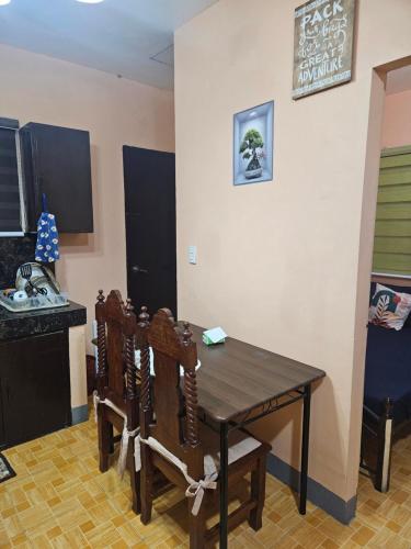 a kitchen with a wooden table and some chairs at Mel's Place Batangas Unit 2 Two Bedroom House w Free Parking WIFI Smart TV Netflix Hot & Cold Shower in Batangas City