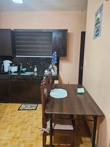 a wooden table and chairs in a kitchen with a counter at Mel's Place Batangas Unit 2 Two Bedroom House w Free Parking WIFI Smart TV Netflix Hot & Cold Shower in Batangas City