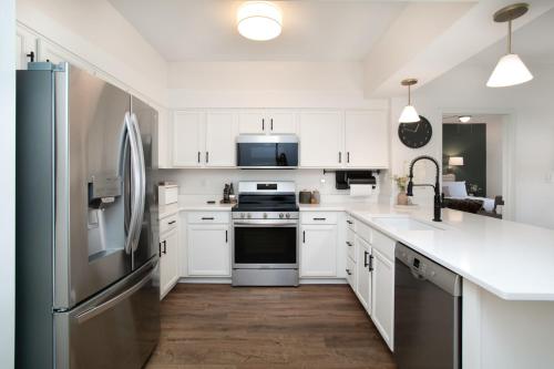 a kitchen with white cabinets and a stainless steel refrigerator at Rivertowne Escape Downtown Knoxville in Knoxville