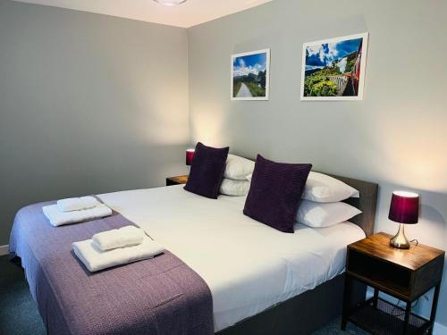 a bedroom with a bed with two towels on it at Marina Apartments 1 in Corpach