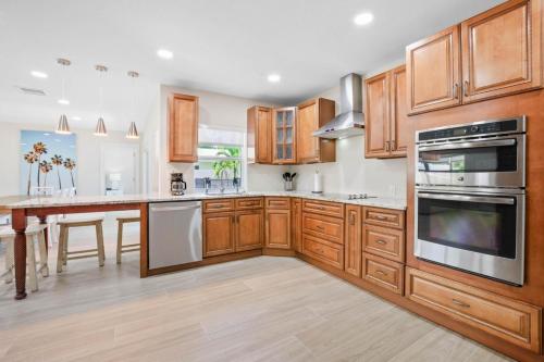 a kitchen with wooden cabinets and a large kitchen island at 4 BD 3BA Heated Pool Close to Beach in Boca Raton