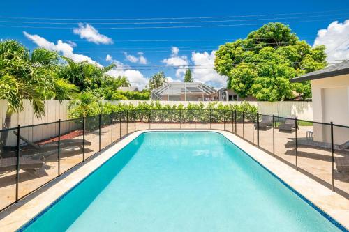 a swimming pool with a fence around it at 4 BD 3BA Heated Pool Close to Beach in Boca Raton