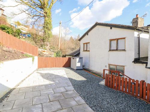 a white house with an orange fence and a driveway at Minffordd in Abergele