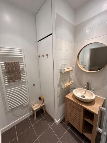 une salle de bain avec un lavabo et un miroir dans l'établissement T3 rénové, au calme, plein centre et climatisé, à Montpellier