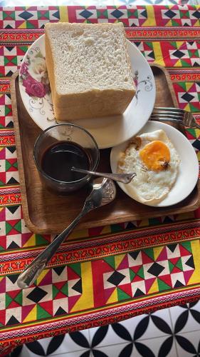 un plato de huevos y pan en una mesa en Rosie Homestay Hà Giang, en Ha Giang
