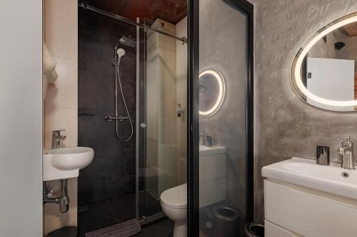 a bathroom with a shower and a toilet and a sink at Masoch. Hotel & Cafe in Lviv
