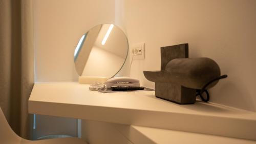 a table with a mirror and a chair on it at Neo Suites in Fira