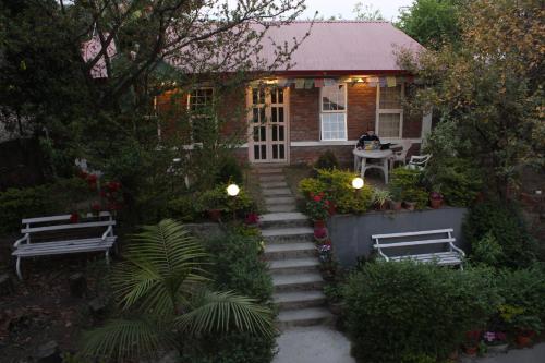 a house with stairs leading up to it with two benches at KAJI HOME in Pātan