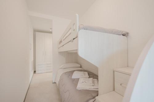 a small white room with a bed and a staircase at Dauli Suite - tra Venezia e Padova & Parcheggio in Dolo
