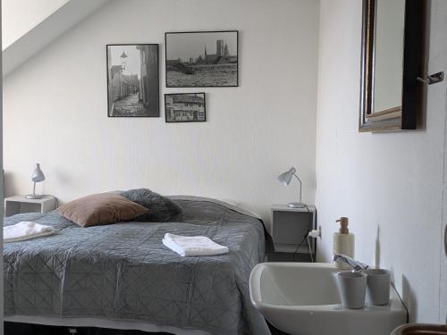 a white bedroom with a bed and a sink at Restaurant Backhaus in Ribe