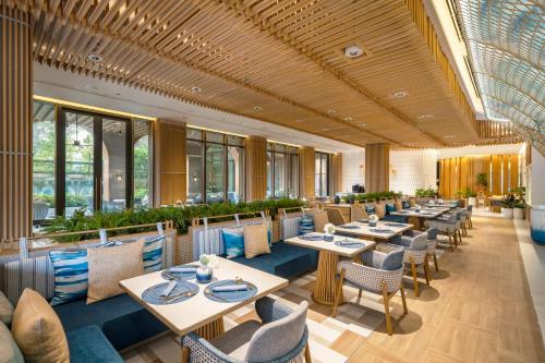 a restaurant with tables and chairs and windows at Meliá Pattaya Hotel in Pattaya Central